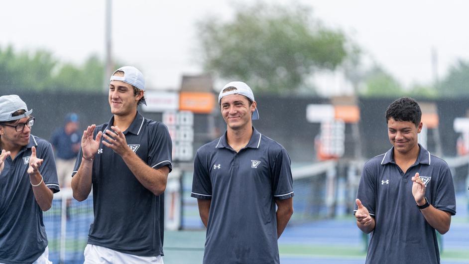 Men's tennis team captain Emilien Burnel, center, is applauded by his teammates during the Senior Day ceremony before the match April 7.